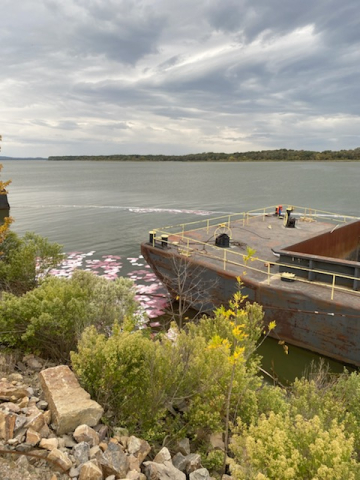 A vessel with pollution boom around it.