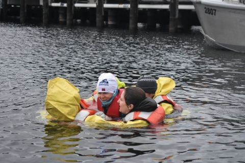 A group of people huddle together in water.