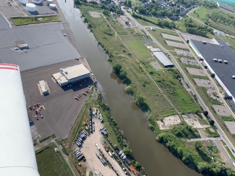 An aerial view of an urban waterway with a visible oil sheen in it. 