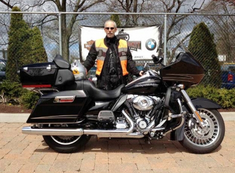 A man standing behind a motorcycle. 