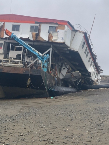 A grounded barge on a beach. 