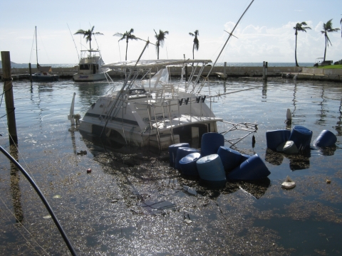 A partially sunken vessel at a marina.