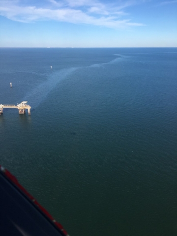 An aerial view of an oil sheen coming from a platform. 