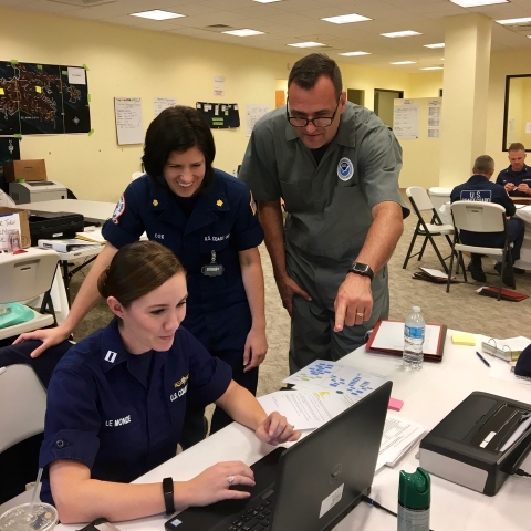 Three people looking at a computer screen. 