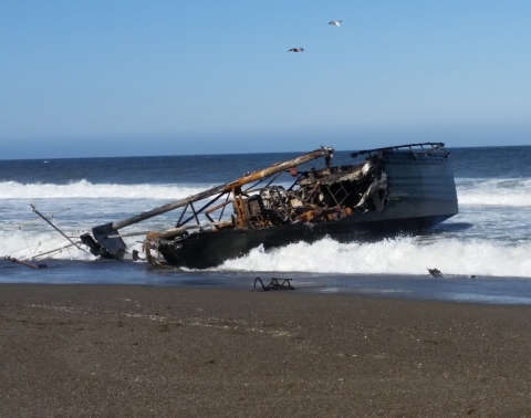 A wrecked vessel on a beach. 
