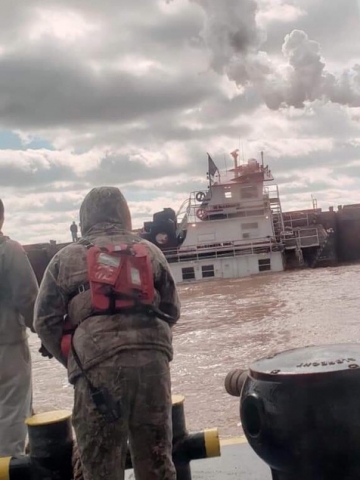 Two people watching a vessel sink. 
