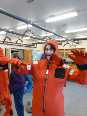 A three-quarters profile shot of a woman in an orange wet suit. 