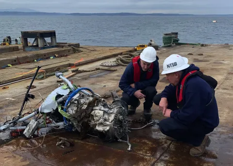 Two people looking at plane debris.