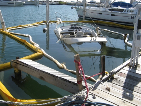 A sunken vessel surrounded by pollution boom. 