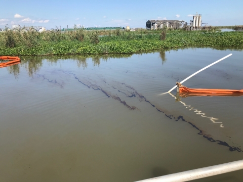 Pollution boom around oil in a body of water. 