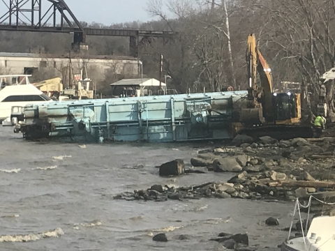 A shipping container being pulled ashore. 