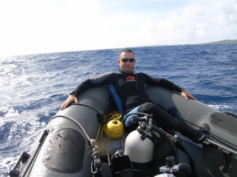 A man in a diving suit on a raft.