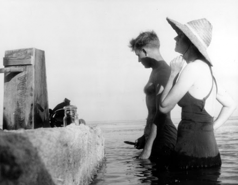 Two people in bathing suits standing in the water.