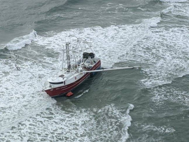 An aerial image of a fishing vessel listing to the side. 