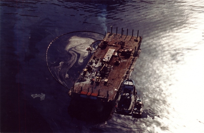 An aerial view of an oil slick next to a vessel. 