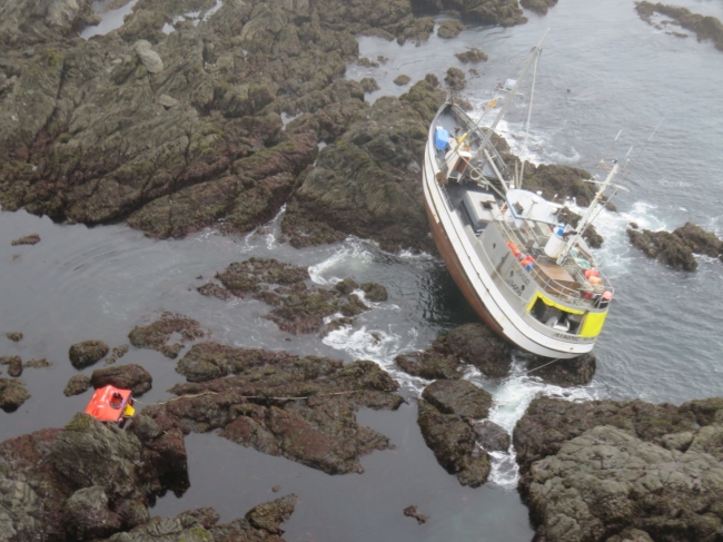 A grounded vessel on a rocky shoreline.