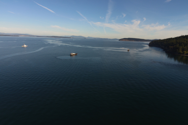 An aerial image of an oil sheen with response vessels near it.