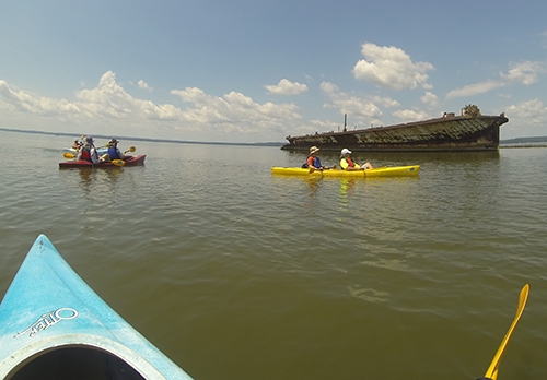 Kayaks approach what is left of an old vessel.
