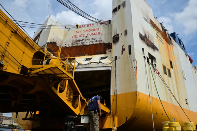 Worker standing near a disabled vessel.