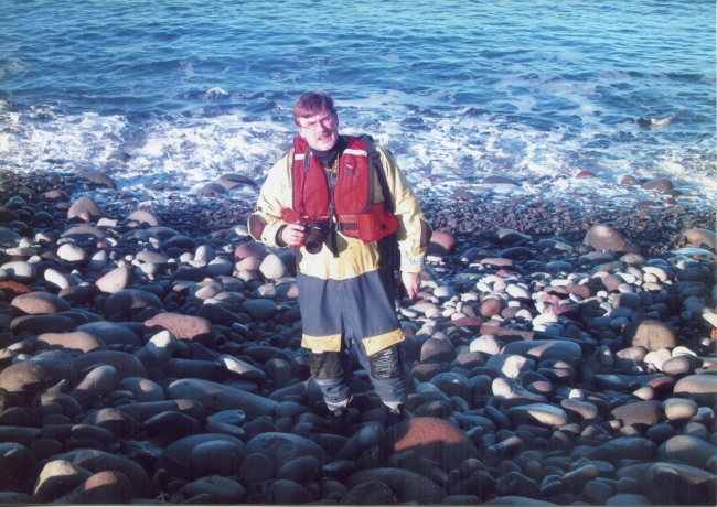 A man on a rocky beach.