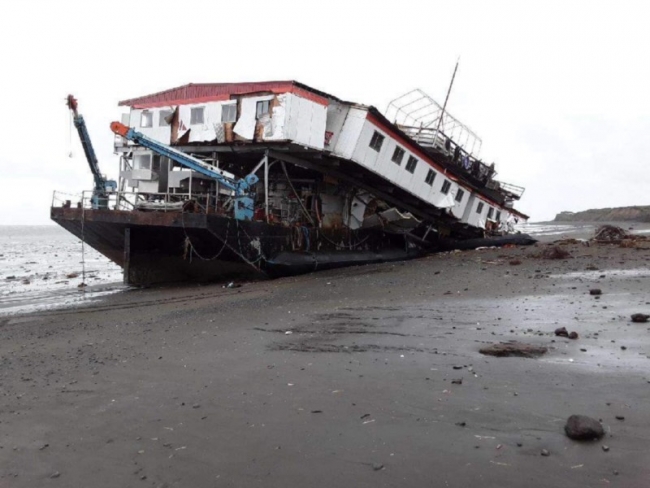 A grounded barge on a beach. 