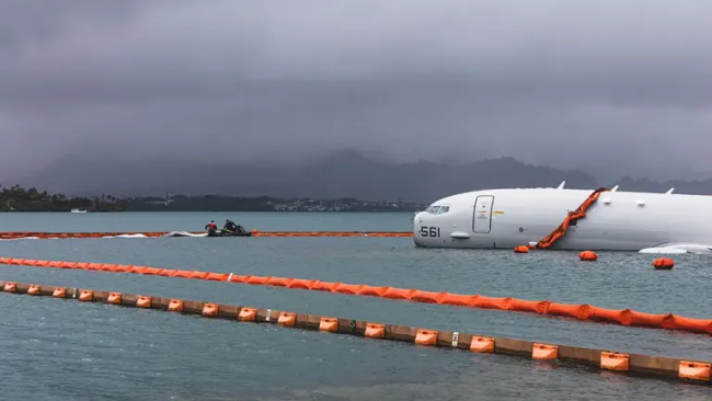 Environment containment booms surround a downed Navy aircraft