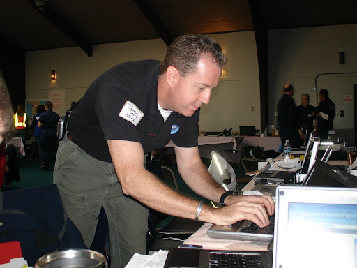 A man leaning over to use a computer.