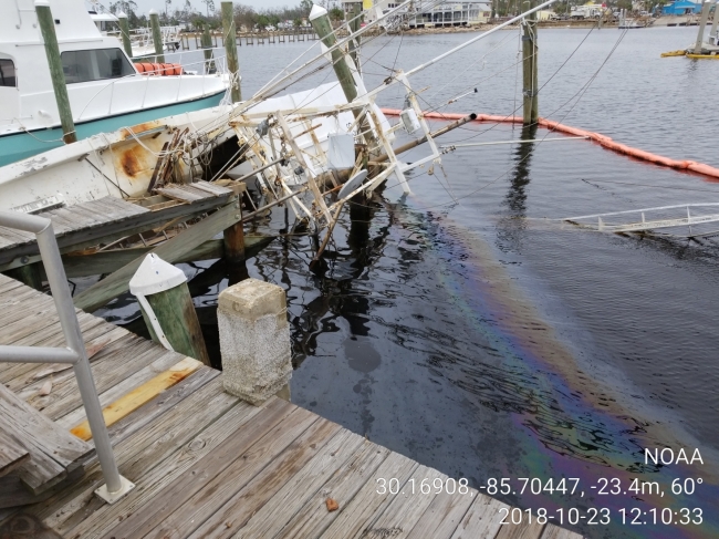An oil sheen around a vessel with pollution boom around it. 