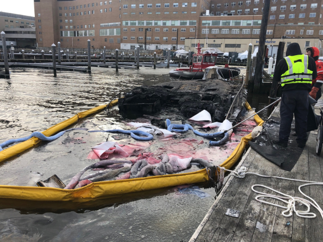 A sunken vessel with pollution boom around it.