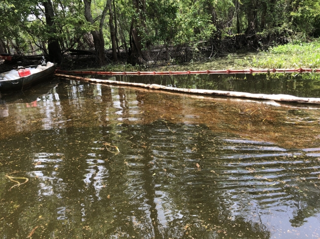 Pollution boom around oil in water.