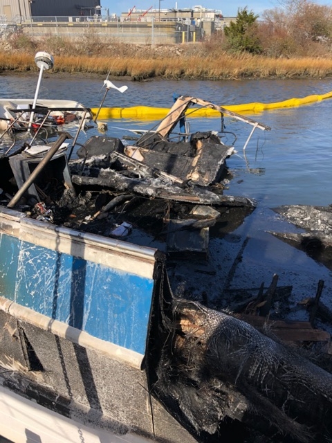 A damaged vessel with pollution boom around it. 