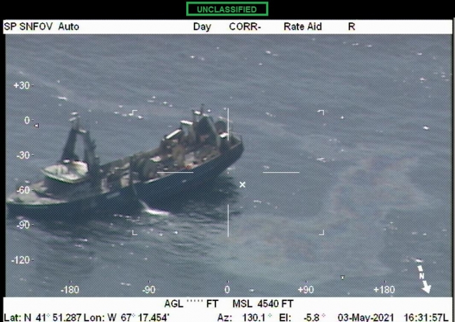 An aerial image of a vessel with a sheen around it. 