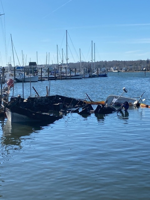 A damaged vessel with pollution boom around it. 