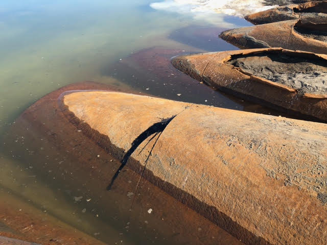 Eroded tanks with tar leaking from them.