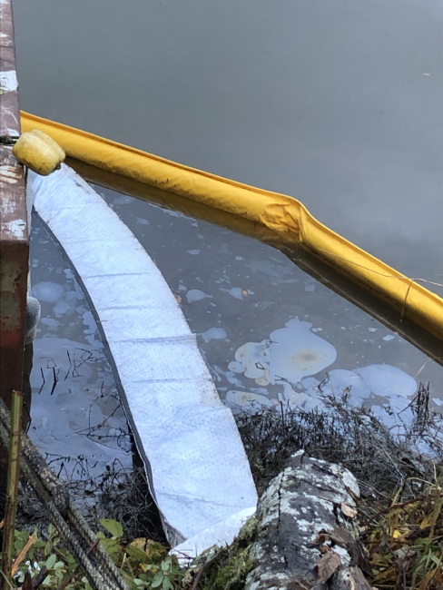 Pollution boom and sorbent in water with an oil sheen.