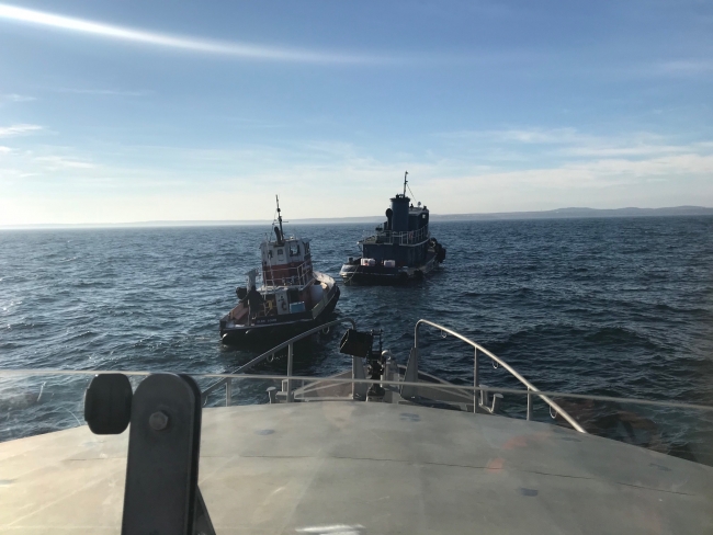 A view of two vessel in water from another vessel. 