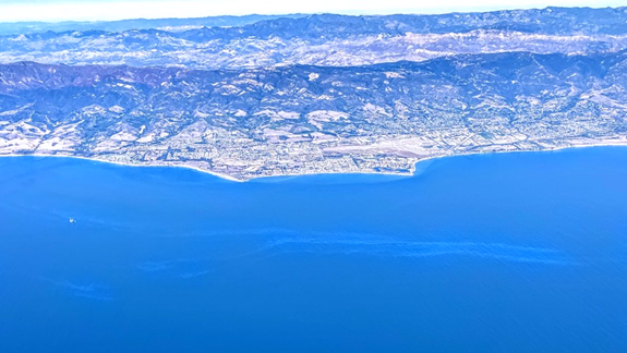 An aerial view of an oil sheen along a shoreline.