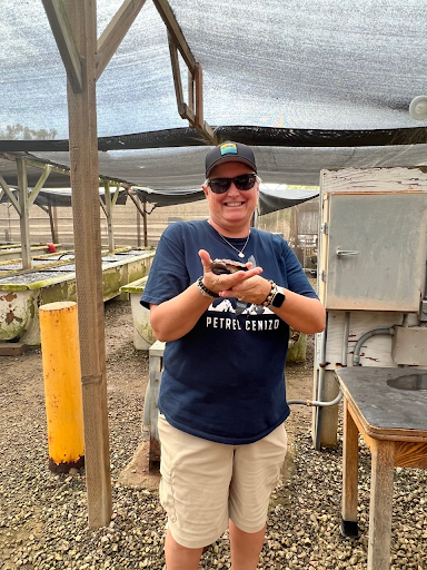 A NOAA staff member holds a red abalone at a abalone farm. 
