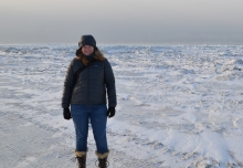 A woman standing on a snowy landscape.