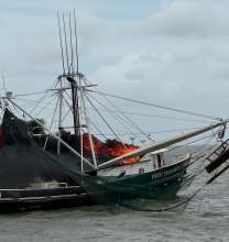 Commercial fishing vessel on fire in Breton Sound, Louisiana.