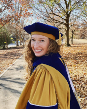 Headshot of Madison at graduation from Georgia Tech, wearing a cap and gown.