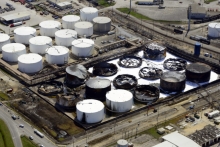 An aerial view of a tank farm with several tanks burned, damaged, and collapsed.