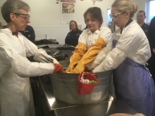 Three people washing a bird in a washbin.