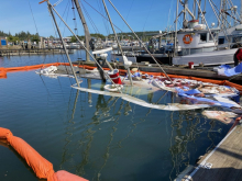 Pollution boom and sorbent around a sunken vessel.