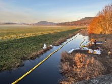 The Olympic Pipeline spill emergency response in Conway, WA. View of Hill Ditch looking north from SR 534. Gasoline is captured by the boom on the right side of the ditch and removed from the ditch by a skimmer. Image credit: Washington Department of Ecology.