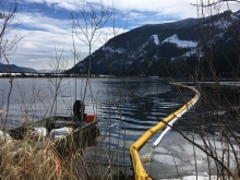 Pollution boom in water with mountains in the background. 