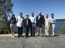 Seven people pose together for a photo in front of Lake Washington. 