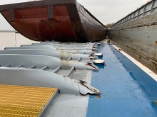 Visible damage to a barge and a sinking towing vessel. 