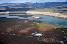 An aerial view of a river passing along an industrial site. 