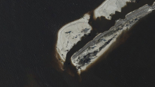 An aerial image of a flooded coastal land area.